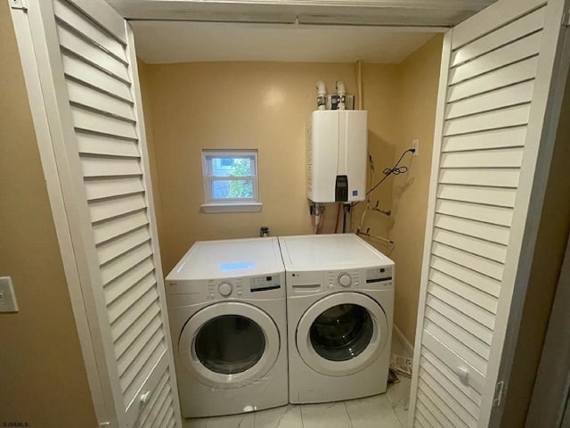 clothes washing area with independent washer and dryer, tankless water heater, and light tile patterned floors