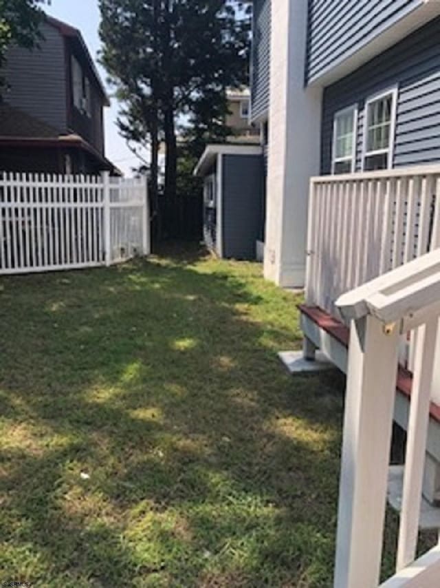 view of yard featuring an outbuilding, fence, and a storage shed