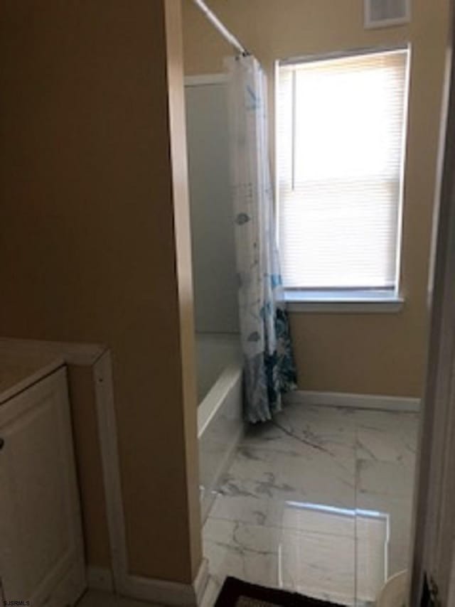 full bathroom featuring visible vents, baseboards, marble finish floor, vanity, and shower / bathtub combination with curtain