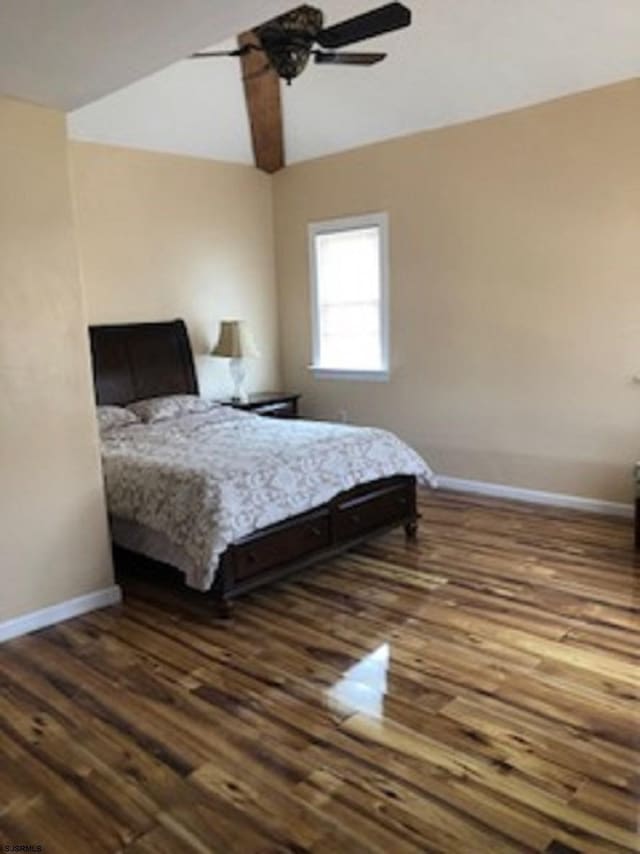 bedroom featuring dark wood-style floors, vaulted ceiling, ceiling fan, and baseboards
