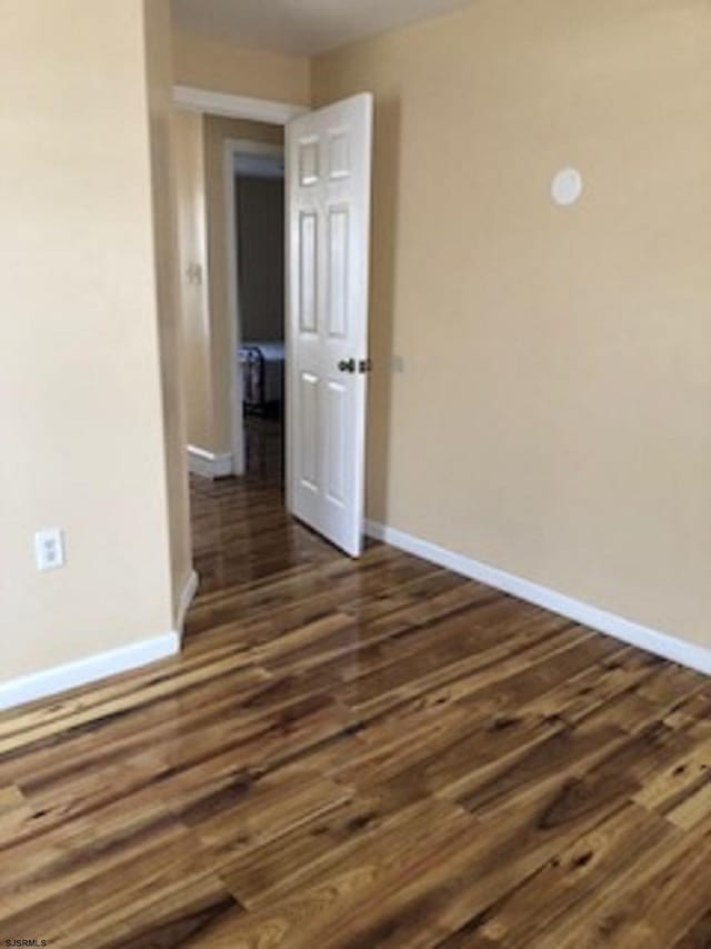 spare room featuring dark wood-type flooring