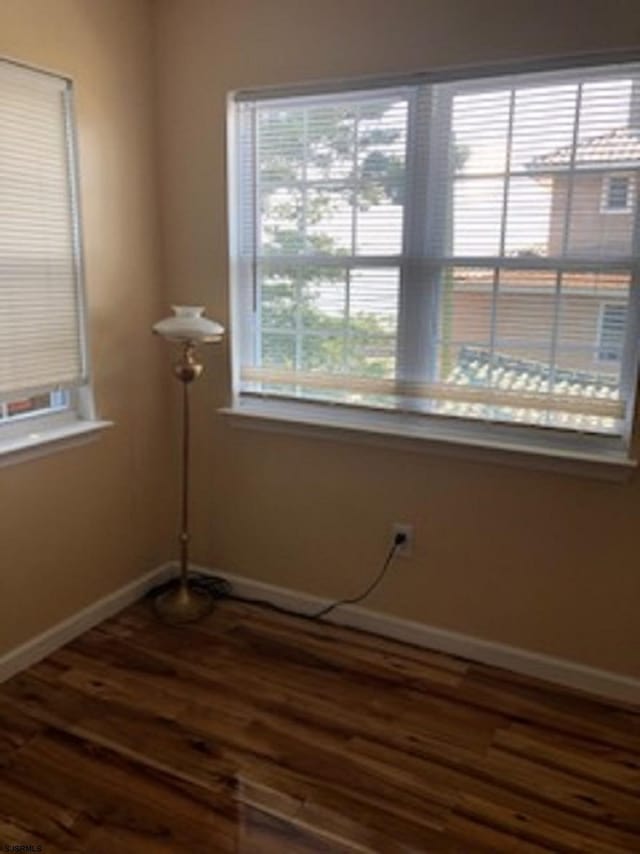 empty room featuring baseboards and wood finished floors