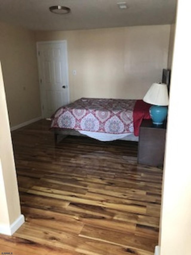 bedroom featuring baseboards and wood finished floors