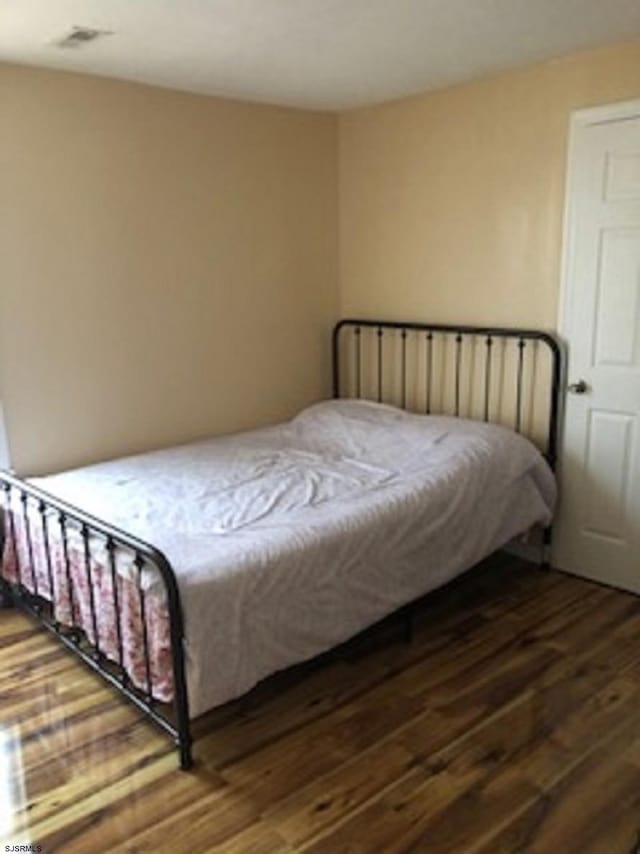 bedroom with visible vents and wood finished floors