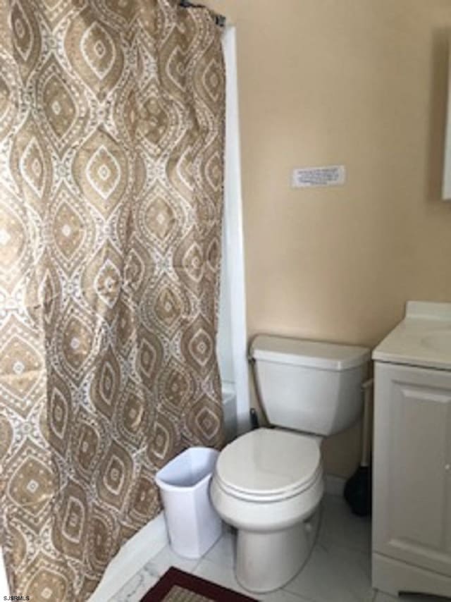 bathroom featuring tile patterned flooring, a shower with curtain, vanity, and toilet