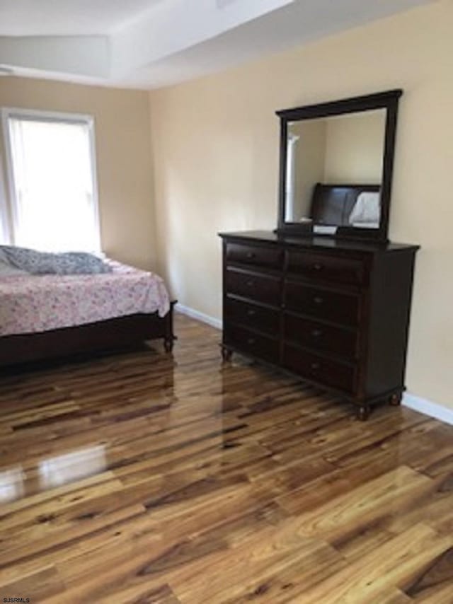 bedroom with baseboards and wood finished floors