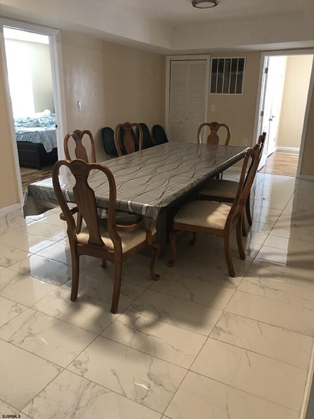 dining area with marble finish floor and baseboards