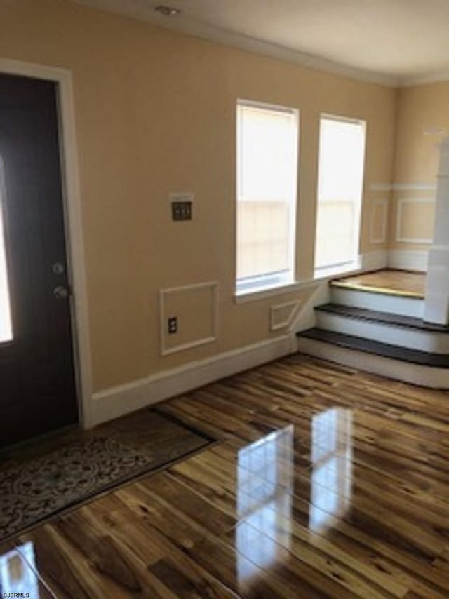 interior space with ornamental molding and dark hardwood / wood-style floors