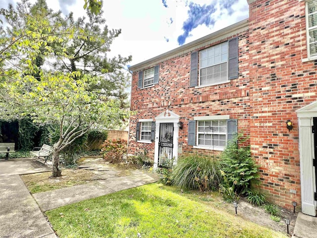 view of front of home with a front yard and a patio