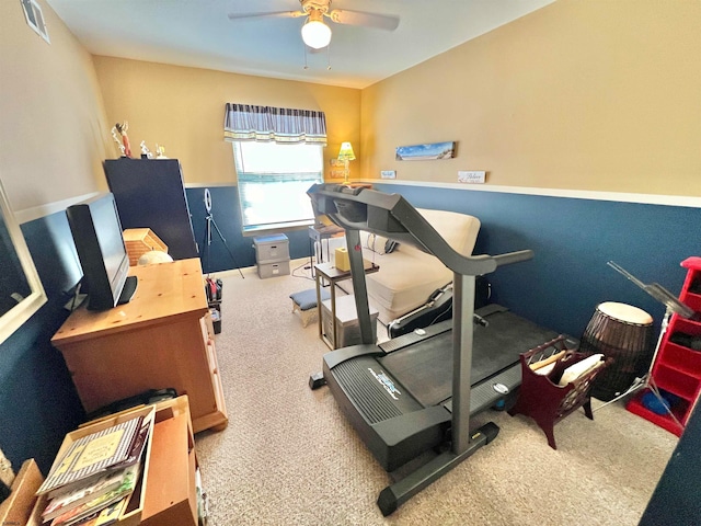 exercise room with ceiling fan and carpet