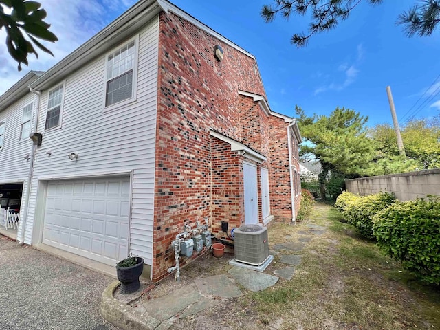 view of property exterior with a garage and central air condition unit