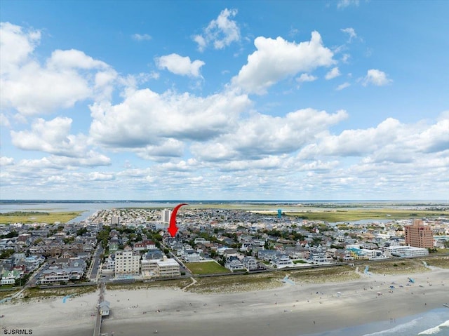 drone / aerial view with a water view and a view of the beach