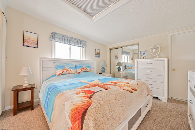 bedroom featuring a closet, light colored carpet, and a textured ceiling