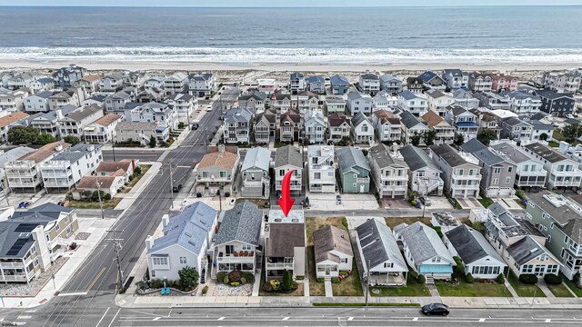 drone / aerial view featuring a water view and a view of the beach