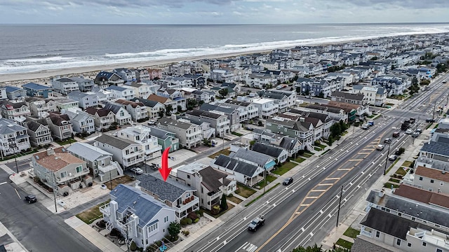 bird's eye view with a water view and a beach view