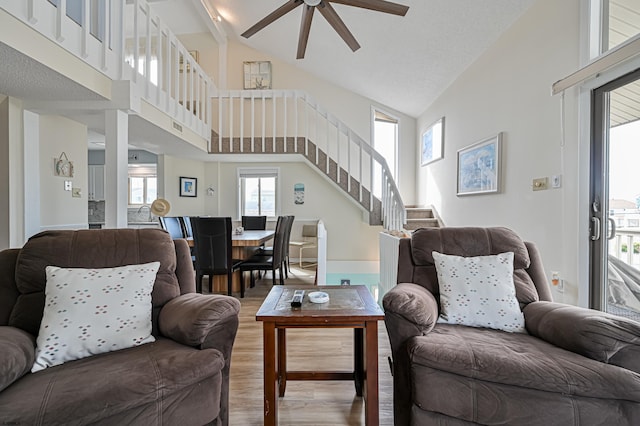 living room featuring high vaulted ceiling, hardwood / wood-style floors, ceiling fan, and a wealth of natural light