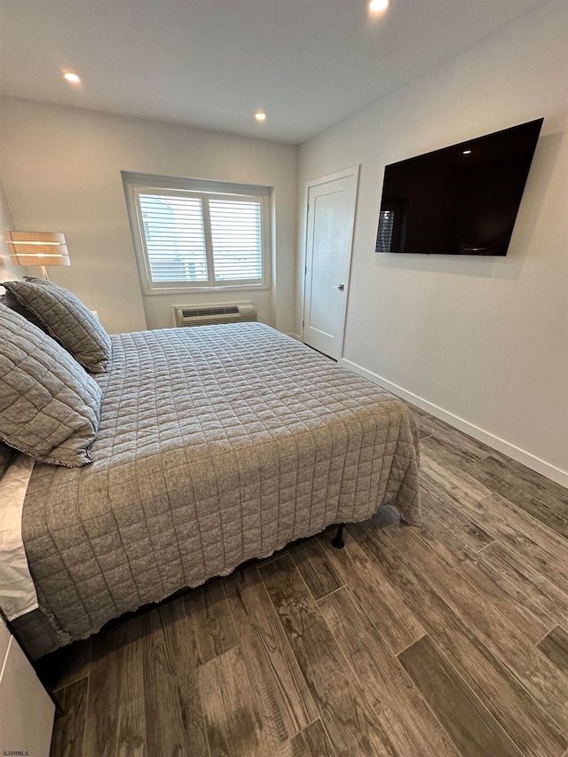 bedroom featuring hardwood / wood-style flooring and a wall mounted air conditioner