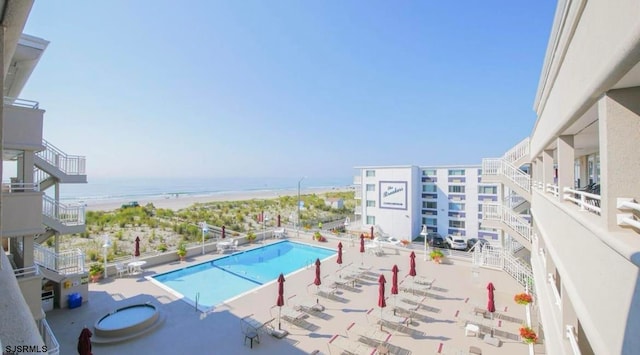 view of swimming pool featuring a water view and a patio area