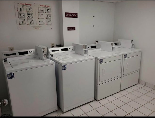 clothes washing area with light tile patterned floors and washer and dryer