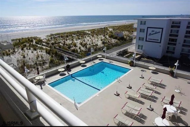 view of pool featuring a view of the beach and a water view