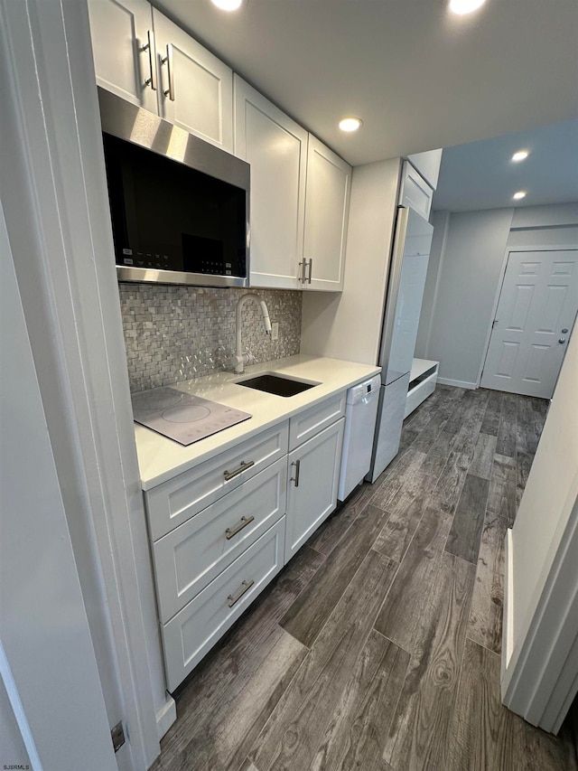 kitchen with white appliances, dark hardwood / wood-style flooring, and white cabinets