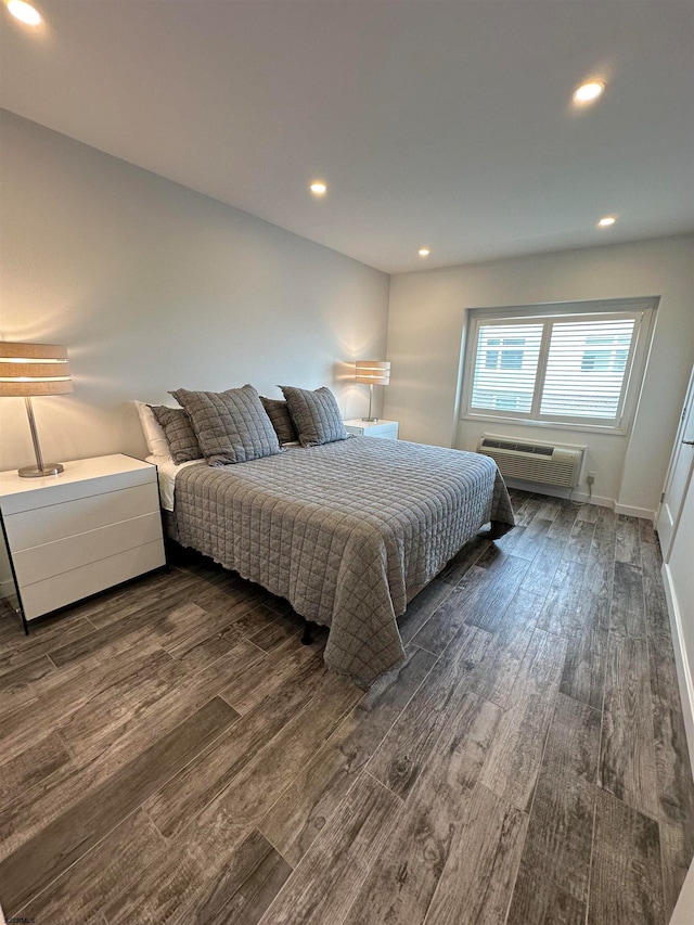 bedroom featuring a wall unit AC and dark hardwood / wood-style flooring