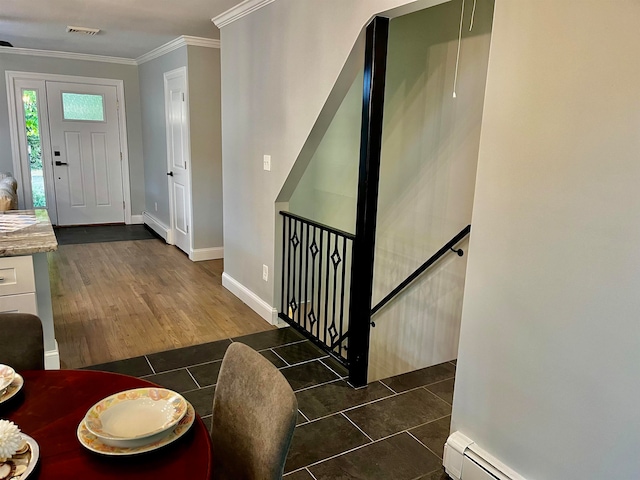 foyer entrance with ornamental molding and dark wood-type flooring