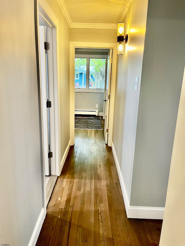 hall with wood-type flooring, baseboard heating, and ornamental molding