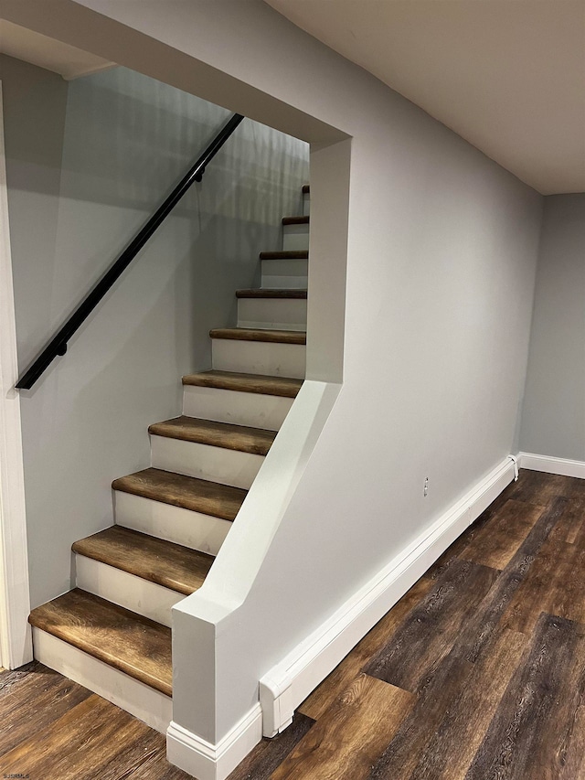 stairs featuring baseboard heating and hardwood / wood-style floors