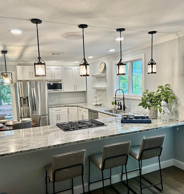 kitchen featuring pendant lighting, stainless steel appliances, and white cabinets