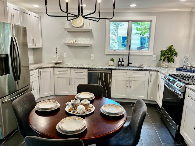 kitchen featuring white cabinetry, stainless steel appliances, decorative light fixtures, sink, and a chandelier