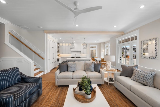 living room with ceiling fan, hardwood / wood-style flooring, and crown molding