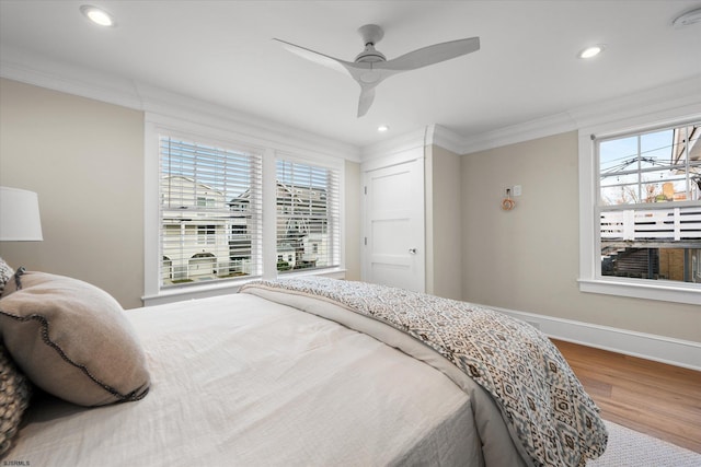 bedroom with ornamental molding, hardwood / wood-style floors, and ceiling fan