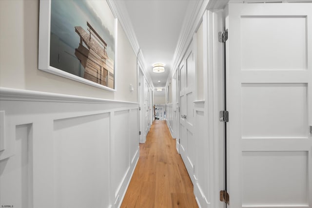 hall with light hardwood / wood-style flooring and ornamental molding