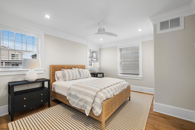 bedroom with crown molding, hardwood / wood-style floors, and ceiling fan