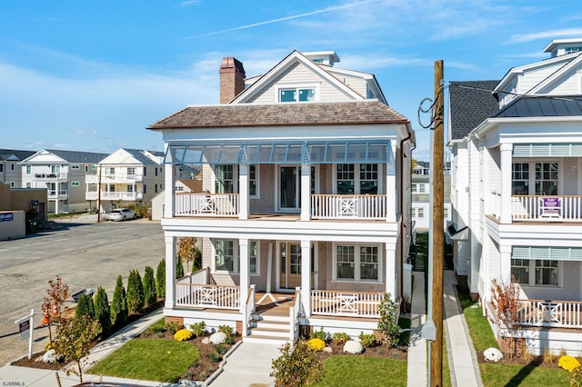 view of front of property featuring a balcony and covered porch