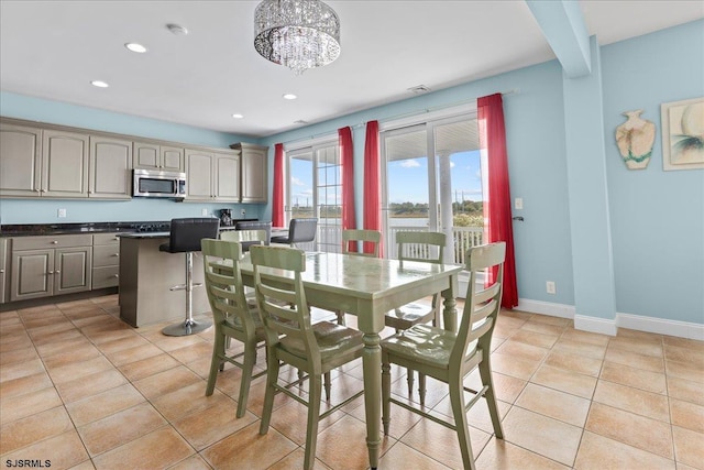 dining area featuring light tile patterned floors and a notable chandelier