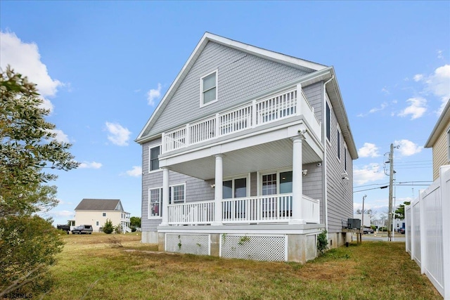 view of front of house featuring a balcony and a front lawn