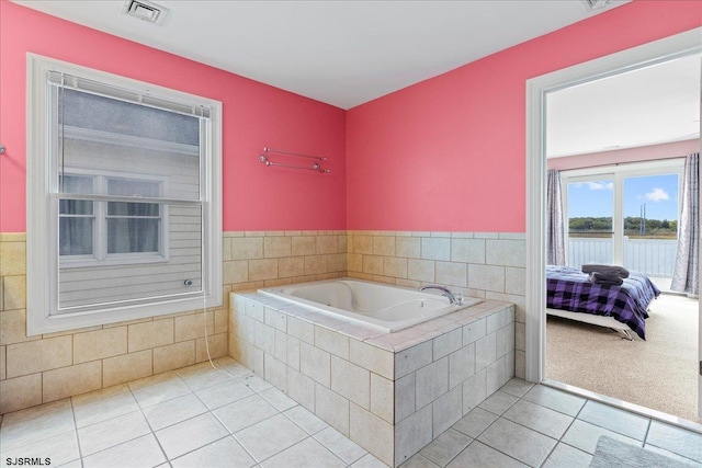 bathroom featuring a relaxing tiled tub and tile patterned floors