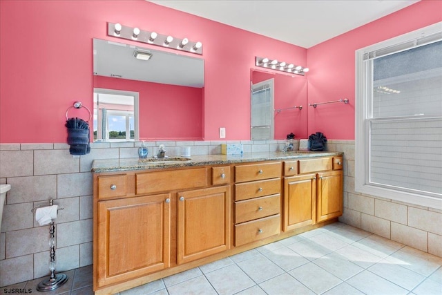 bathroom with tile walls, tile patterned flooring, and vanity