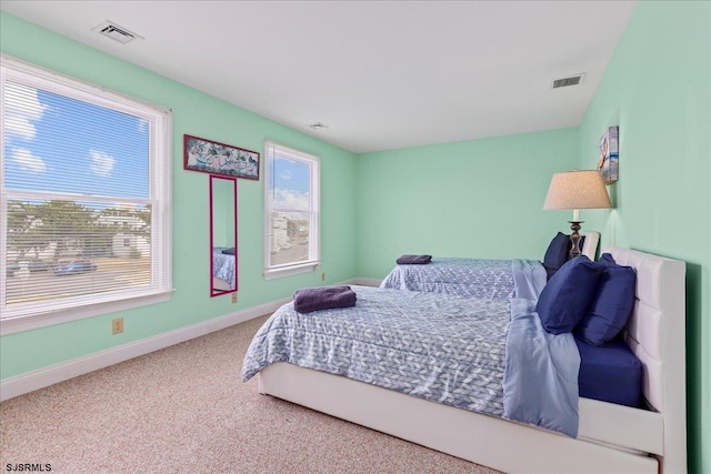 carpeted bedroom featuring multiple windows