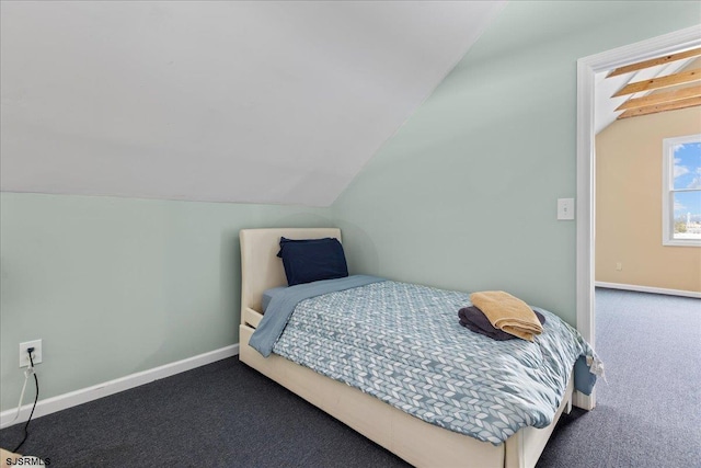 bedroom featuring lofted ceiling and dark colored carpet