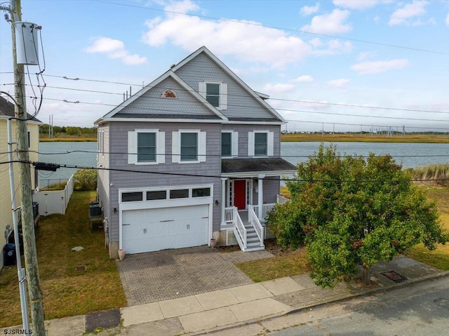 view of front of house with a water view, a garage, and covered porch