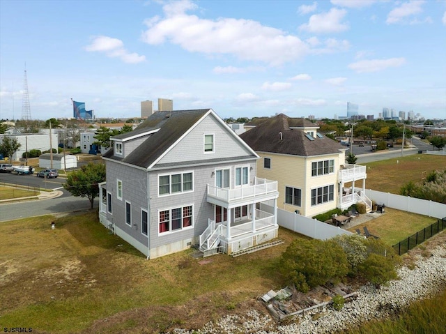 back of property featuring a lawn and a balcony