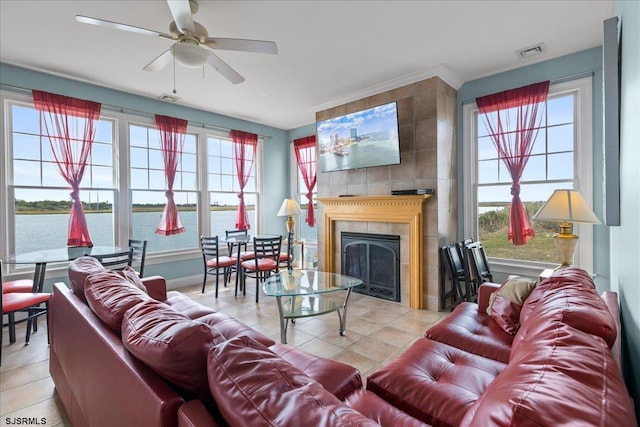 living room featuring a fireplace, light tile patterned flooring, and ceiling fan