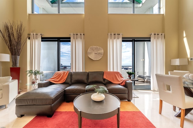 tiled living room with a healthy amount of sunlight and a towering ceiling