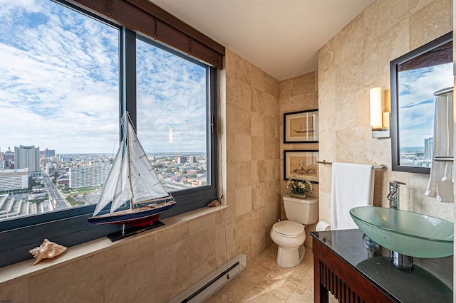 bathroom featuring tile walls, tile patterned flooring, a baseboard radiator, toilet, and sink