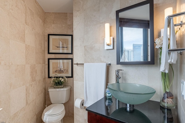 bathroom featuring tile walls, vanity, and toilet