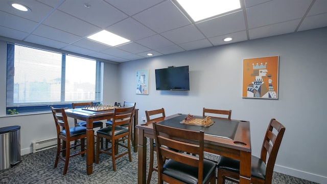 carpeted dining area featuring a paneled ceiling