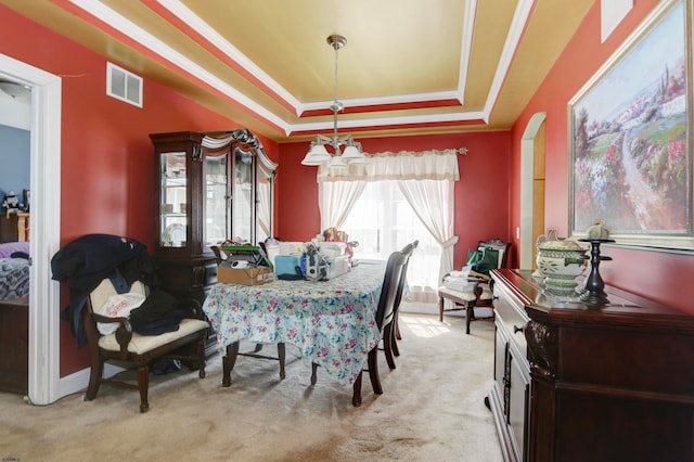 dining space with light carpet and a raised ceiling